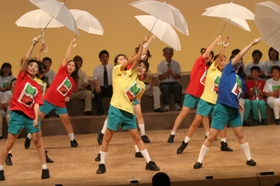 傘をさして踊る若者たちの写真