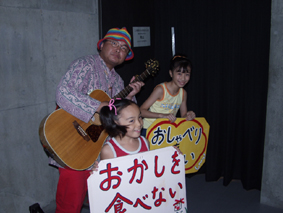 ギターを持つ役者と2人の女の子の写真